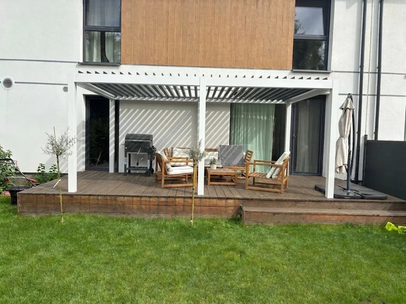 Rear terrace with an approved white pergola frame